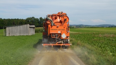 Ligninlauge wird zur Staubbekämpfung auf die Naturstrasse appliziert